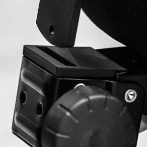A gyárilag összeszerelt háttámlát most vegye kézbe, és a mechanika hátulján található, kiálló foglalatba illessze bele a megfelelő végét. Ha nem menne a lyukba a fém lap, eressze meg a műanyag felületű rögzítő csavart. Később ezzel a csavarra lehet majd a háttámla végleges magasságát is beállítani. Ha minden a helyén, a háttámla fém nyelvébe illessze bele a műanyag kis stiftet, melyet a csavarok mellé kapott. Ez akadályozza meg, hogy szétrántsuk a széket magasságállításnál.
